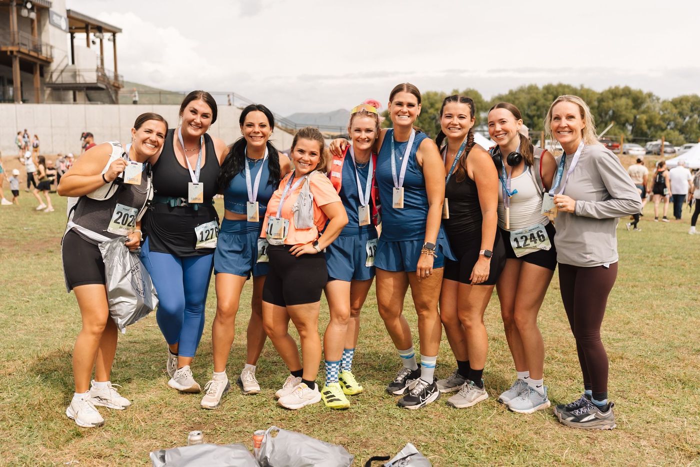 A group of women with finisher medals on the grass.