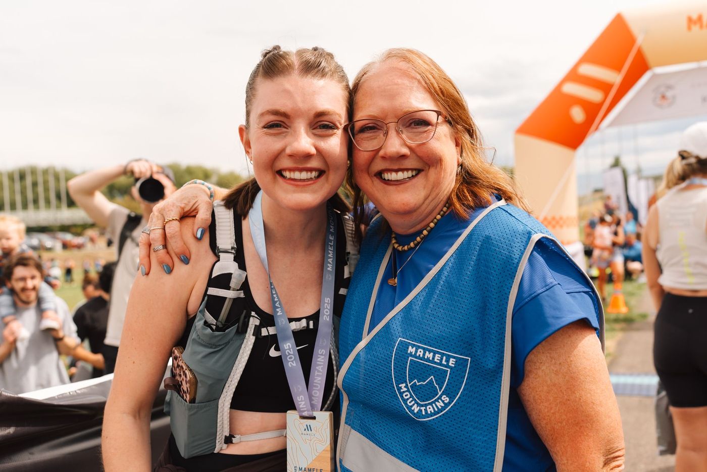 Two women smiling together at the Mamele Mountains finish area.